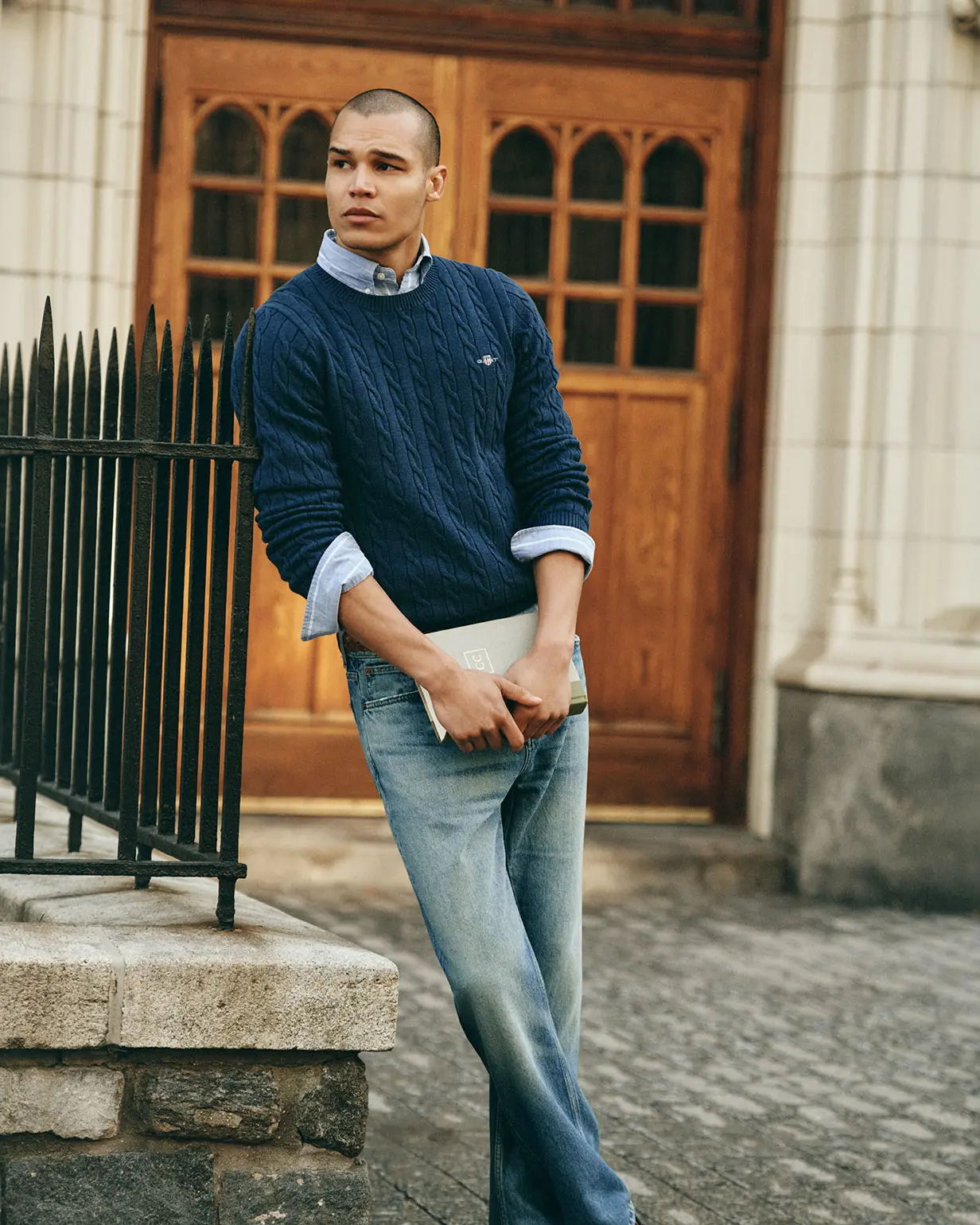 Man wearinf Gant blue knitted jumper and jeans