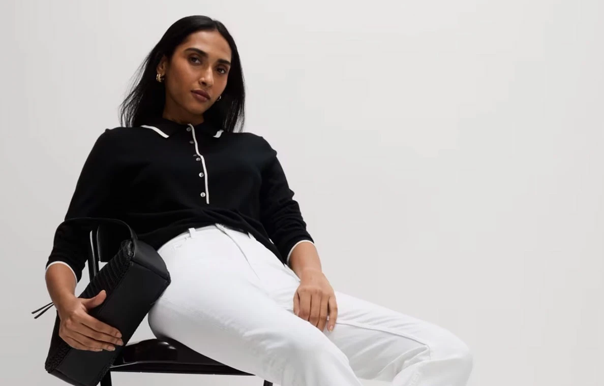 Woman wearing black polo and white jeans