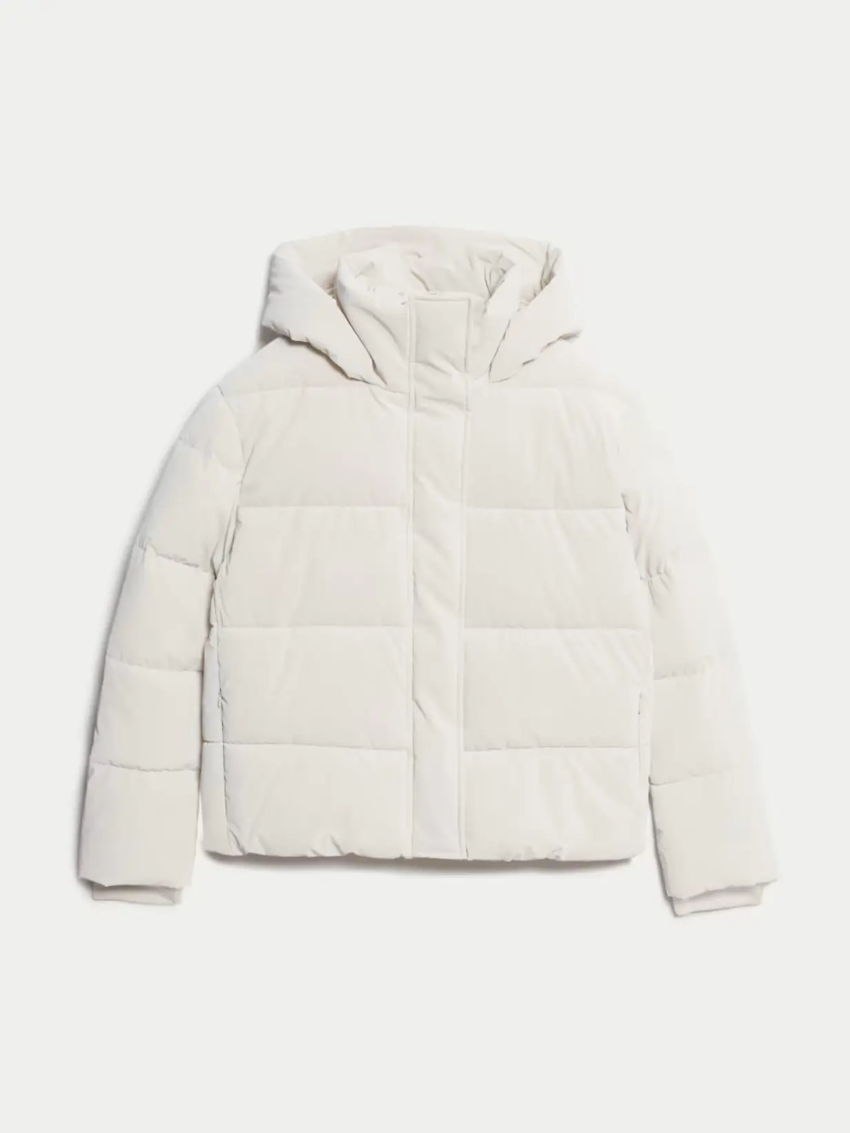 A cutout of a light cream padded cropped puffer jacket against a light background