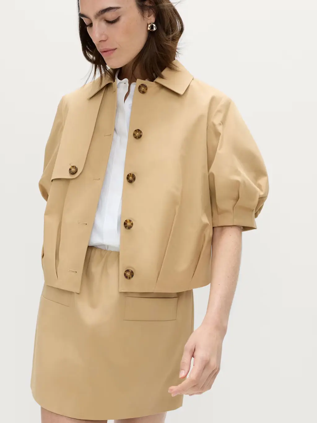 Woman wearing a balloon-sleeve jacket with a white shirt and matching skirt
