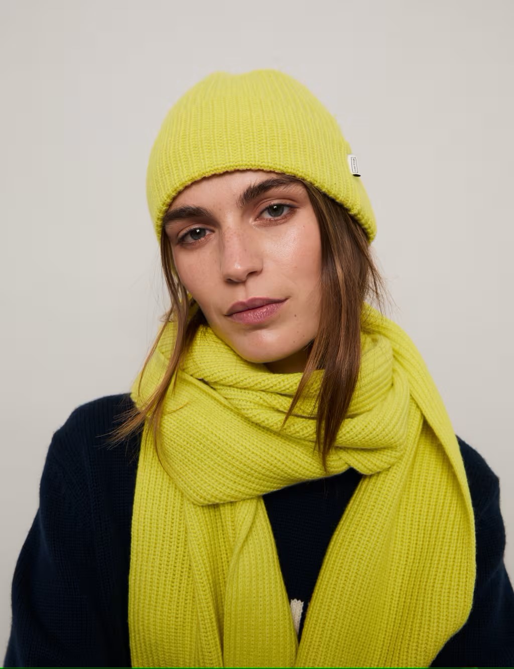 Woman wearing yellow merini wool beanie hat and scarf by M&S x Bella Freud