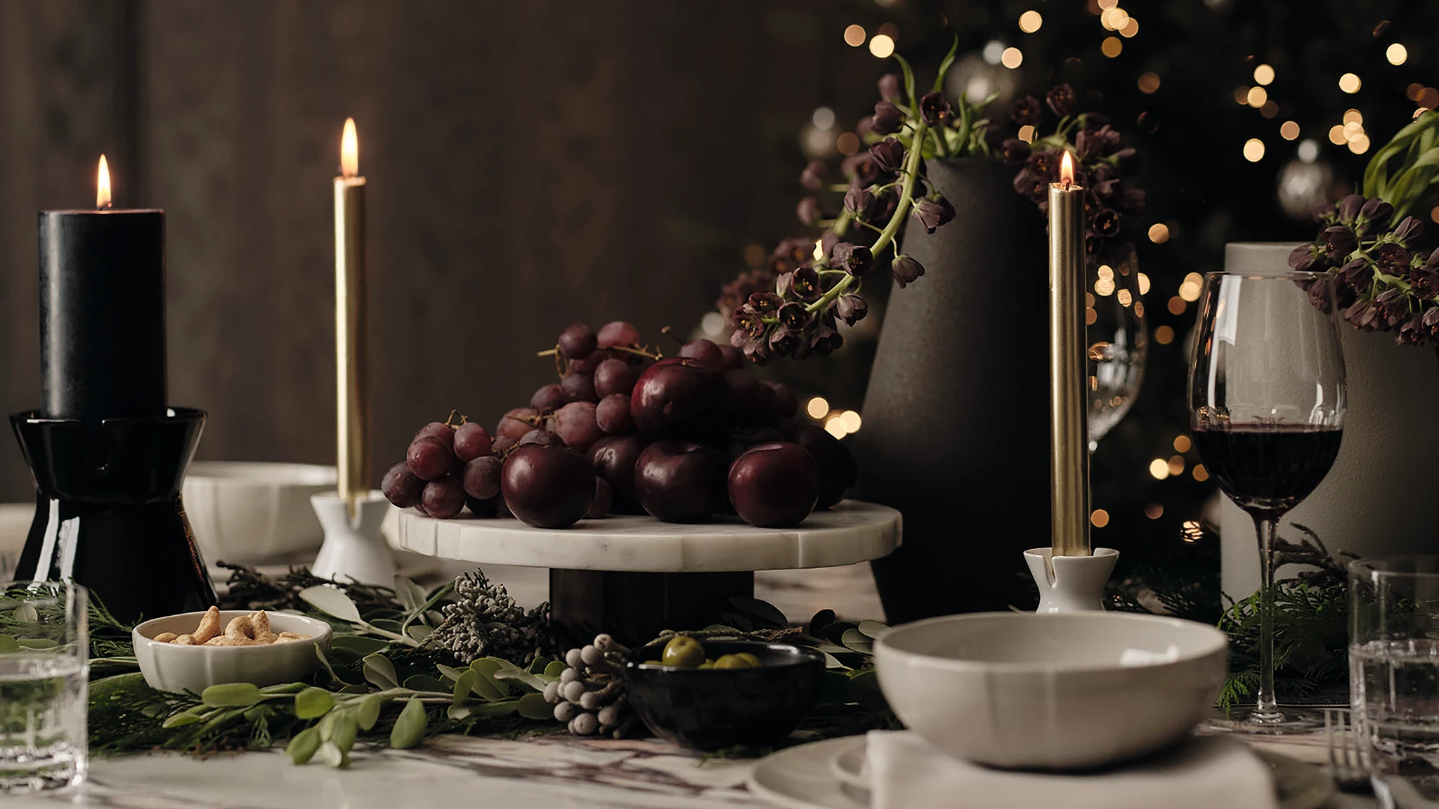 A festive table set with M&S x Kelly Hoppen homewares, taper candles and fruit