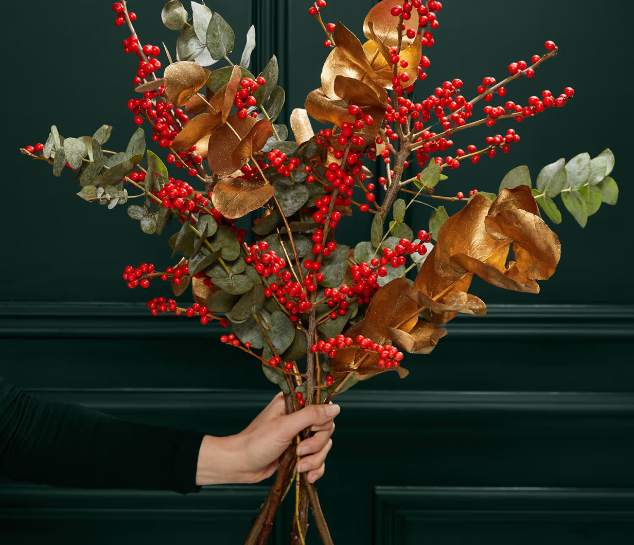 Hand holding festive ilex bouquet