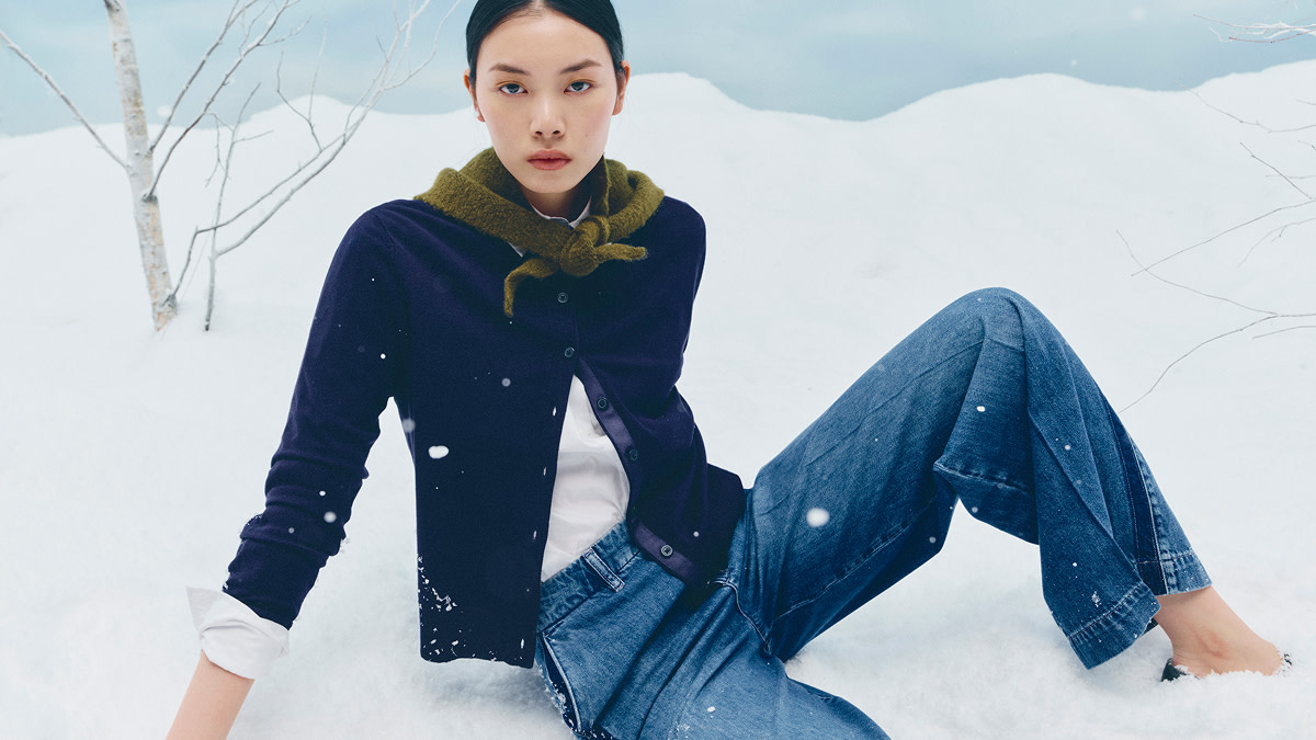 Woman wearing green neckerchief, navy cardigan and blue jeans
