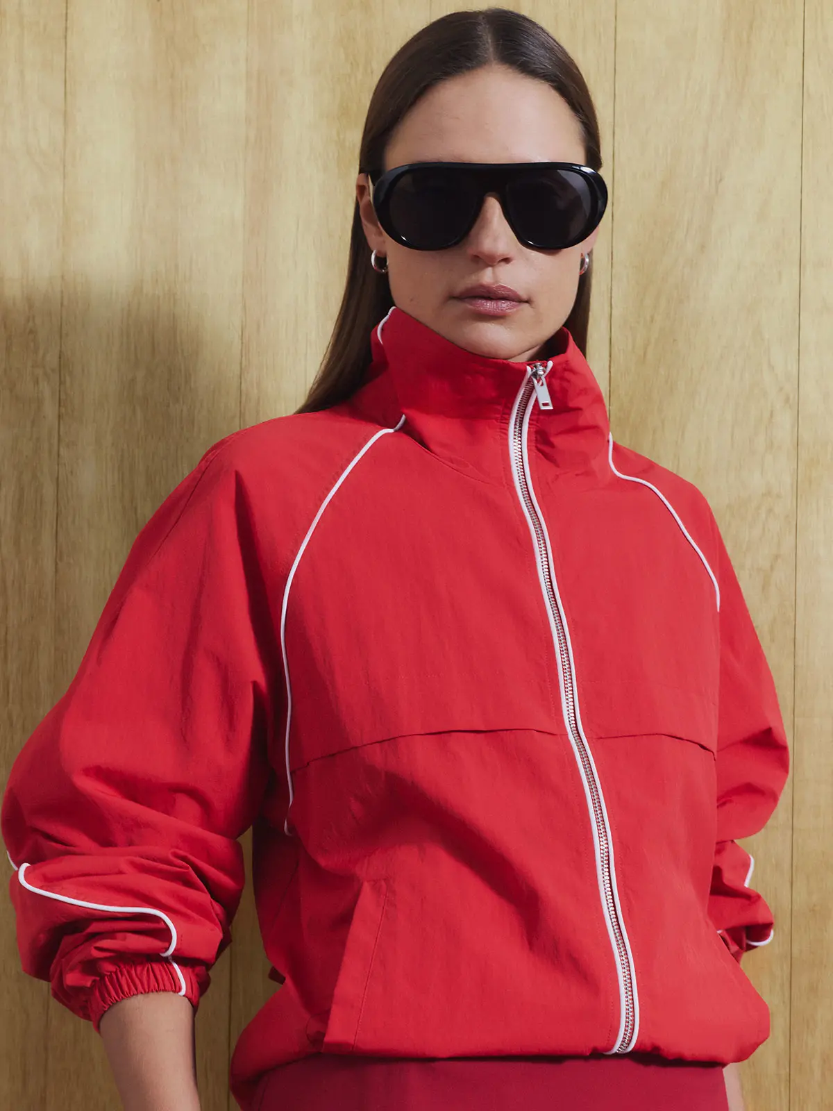 Woman wearing red track jacket and sunglasses 