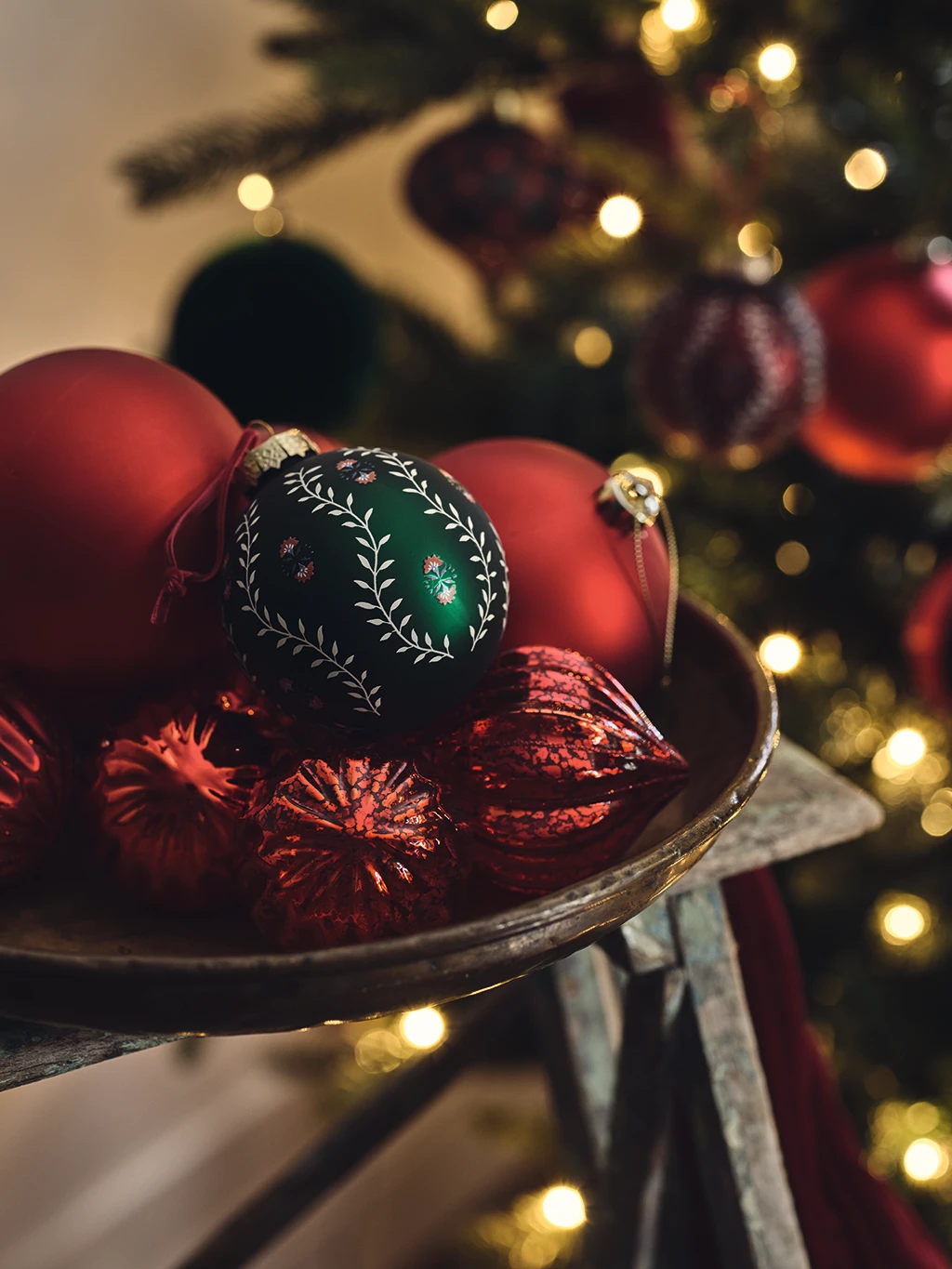 Assorted Christmas baubles in a wooden bowl
