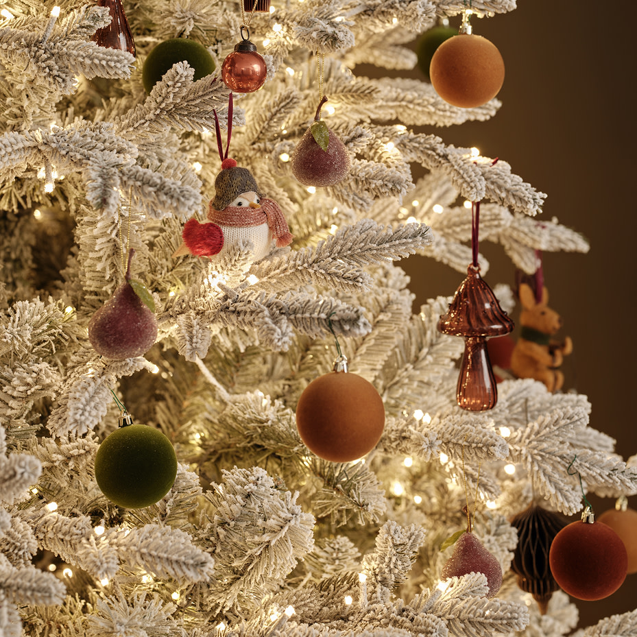Close-up of a white frosted Christmas tree decorated with felt and glass baubles