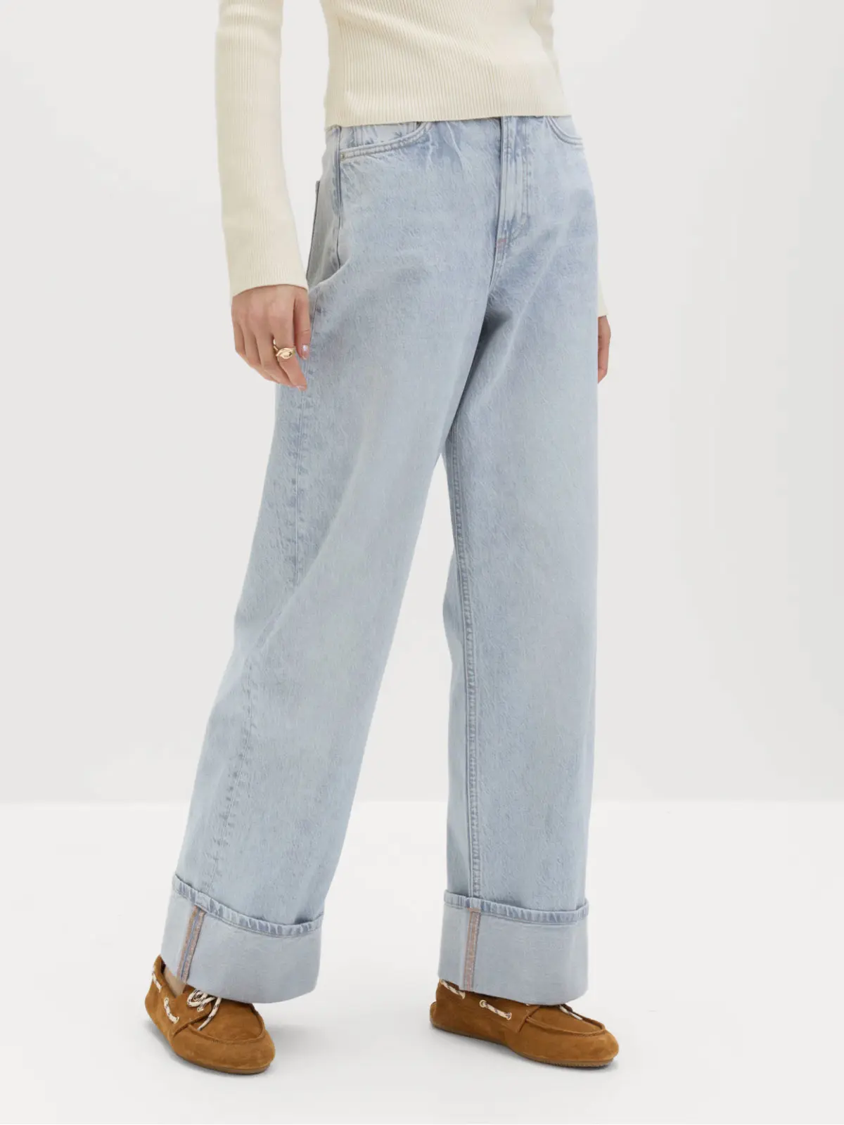 Woman wearing light blue jeans and brown suede boat shoes