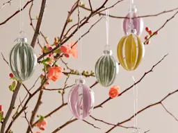 Hand-painted glass Easter egg decorations hanging from a branch