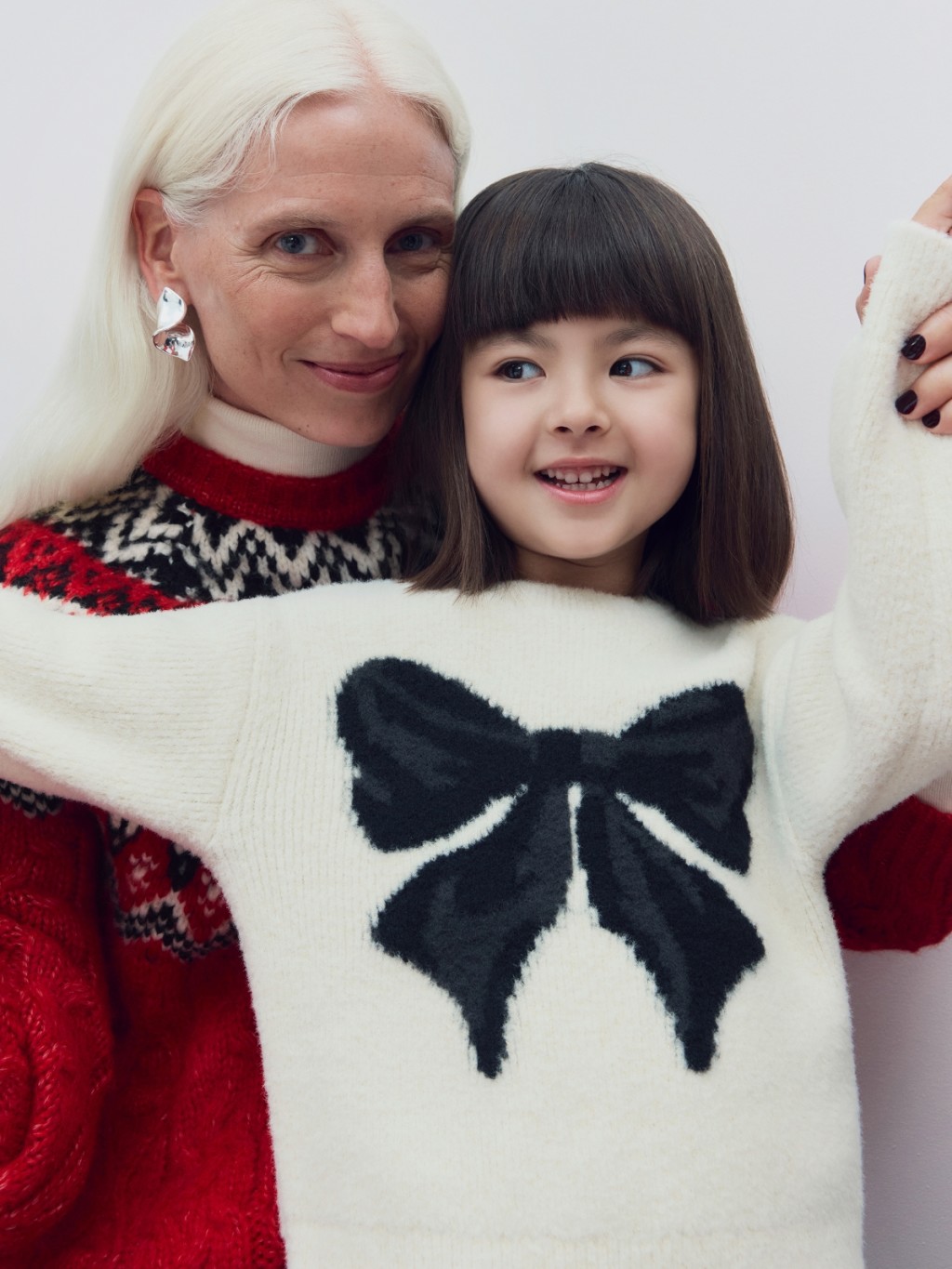 Mom & kid wearing Christmas jumpers 