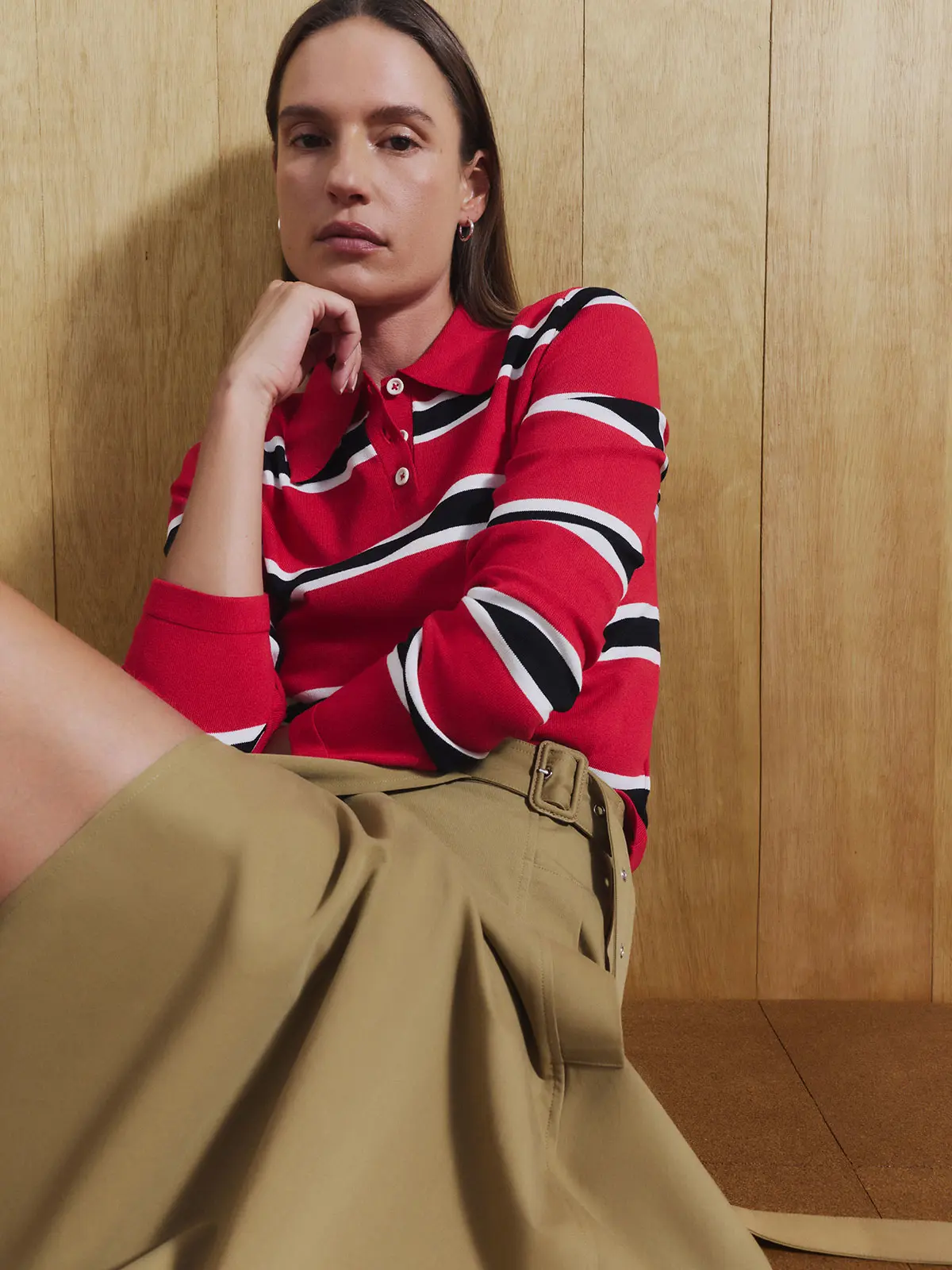 Woman wearing red striped polo and brown skirt