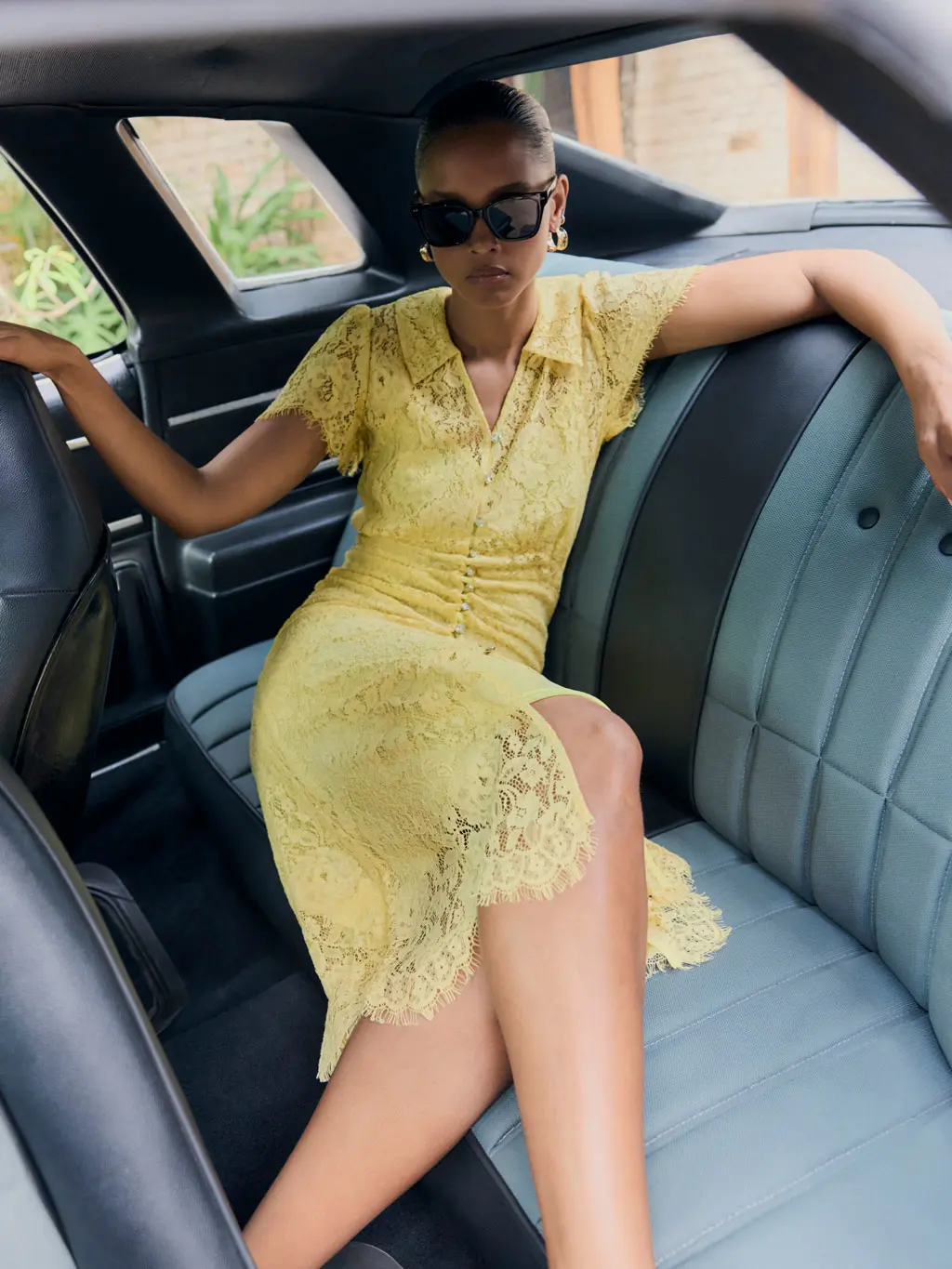 Woman wearing a yellow lace dress in a car