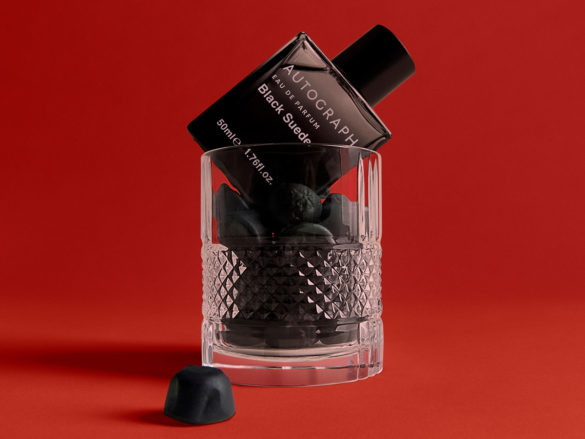 Black cologne bottle in a tumbler glass