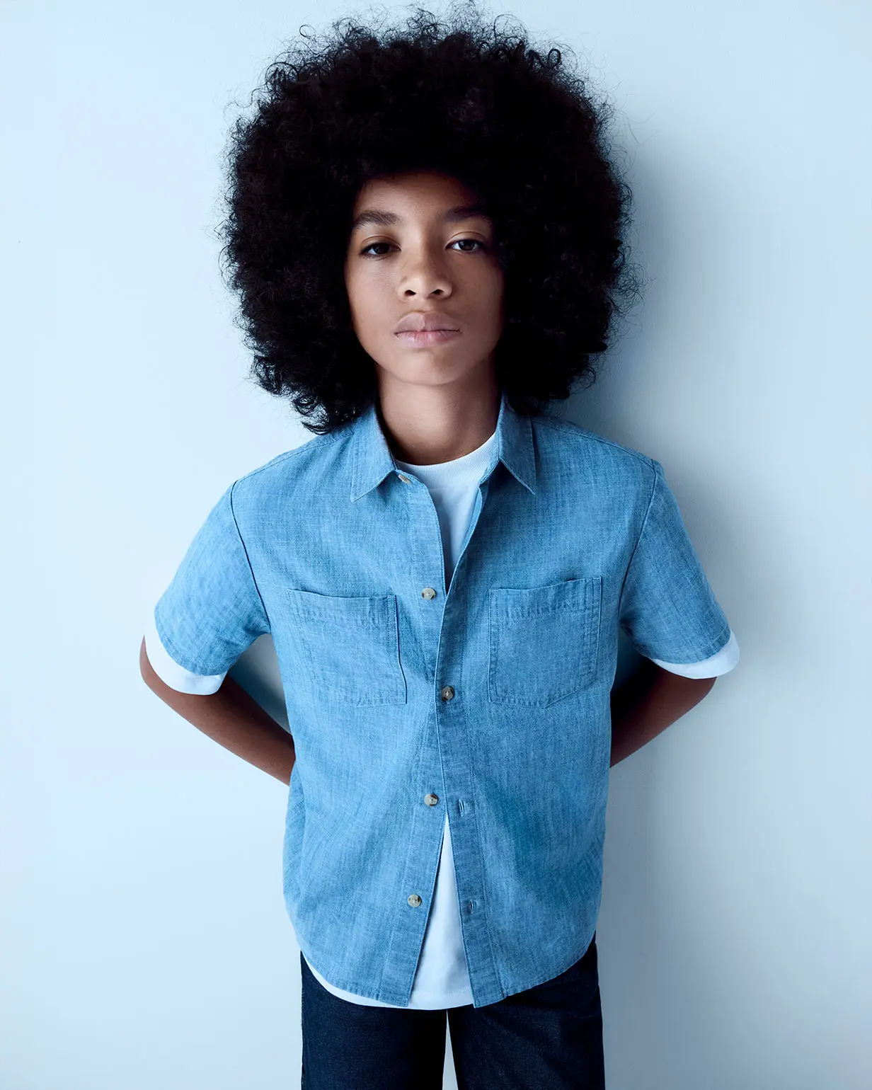 Boy wearing light blue shirt and dark blue jeans