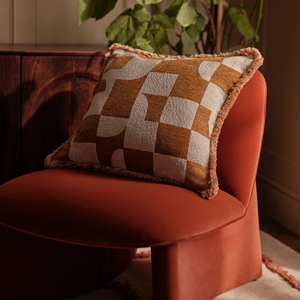 Geometric cushion on a burnt orange velvet chair