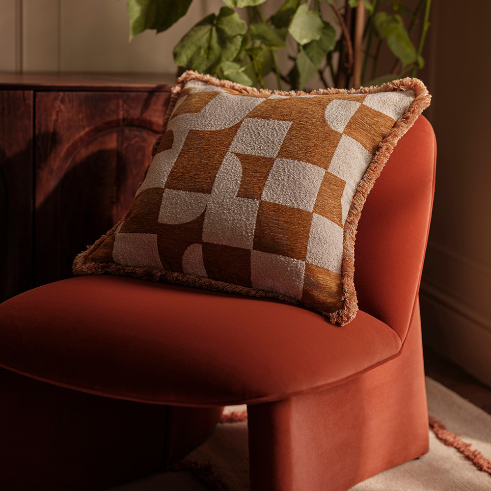 Geometric cushion on a burnt orange velvet chair