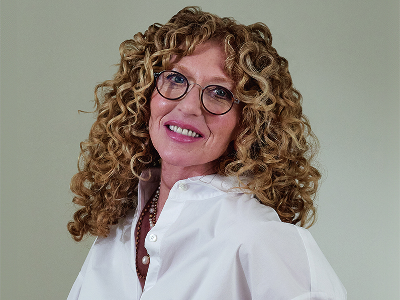 Kelly Hoppen sitting on staircase next to vases from the Kelly Hoppen X M&S collection