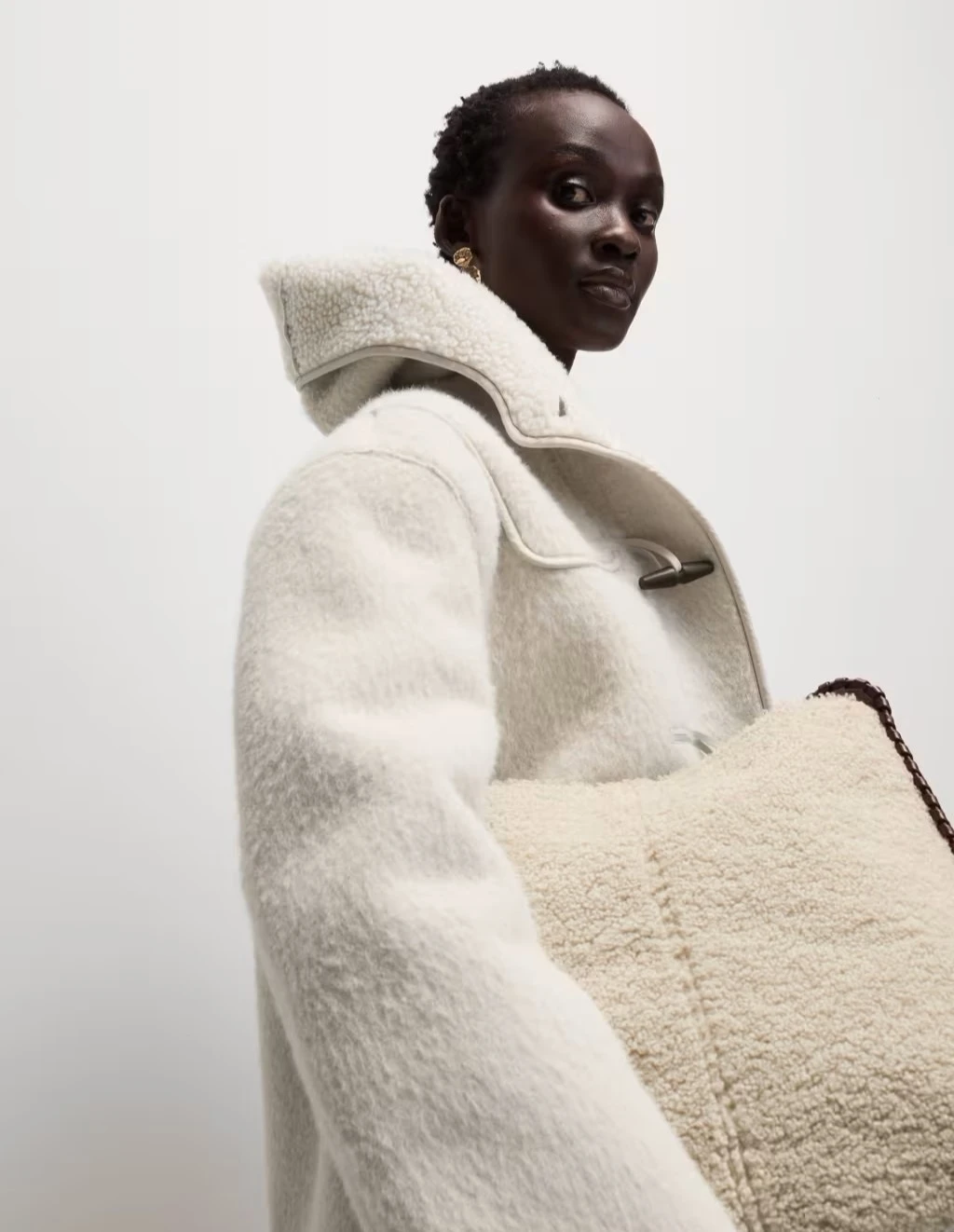Woman wearing cream duffle coat at M&S