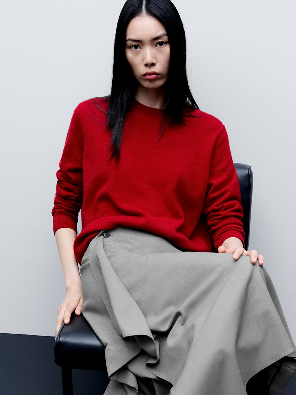 Woman wearing cherry red jumper and grey skirt