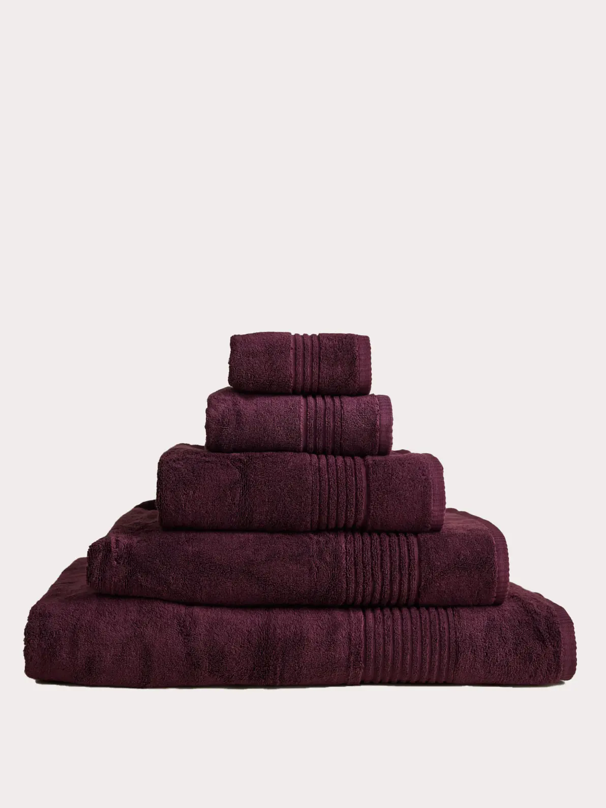 Pile of different sized towels in aubergine 