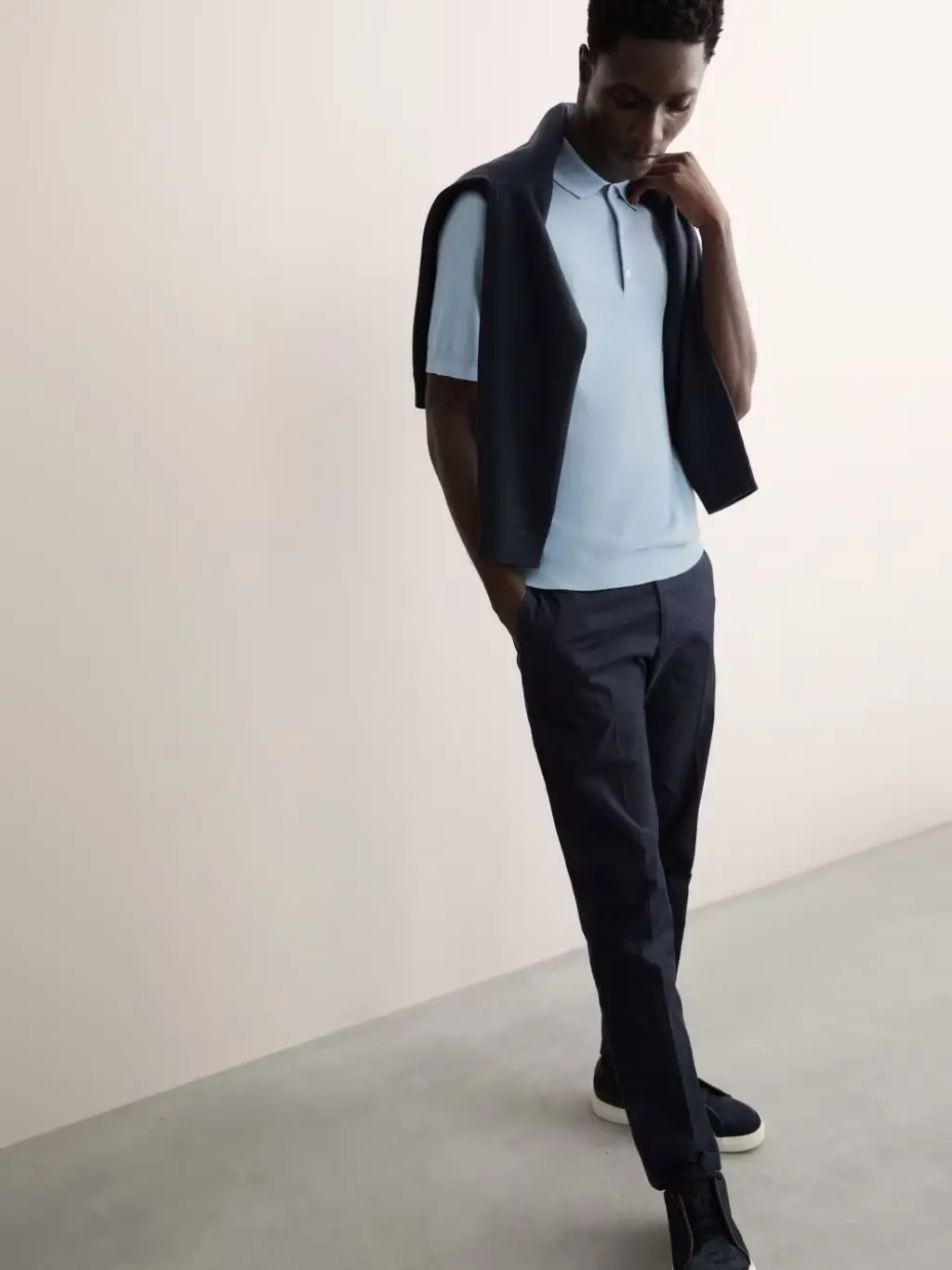 A model looks down to the ground, wearin ga 