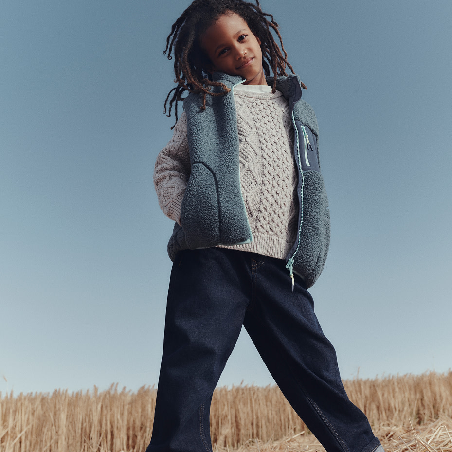 Boy wearing knitwear and a fleece gilet