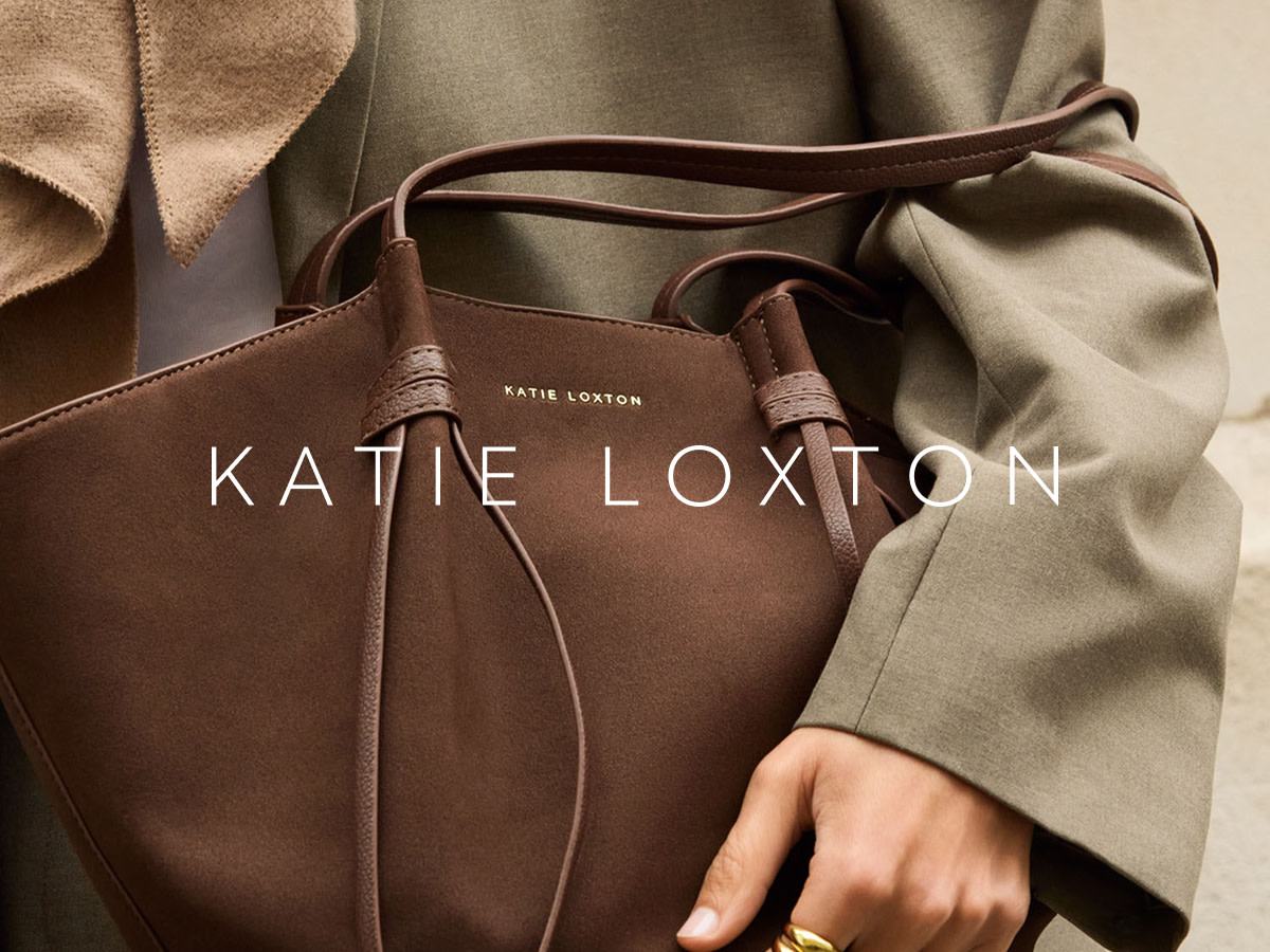 Woman wearing khaki trench holding a brown Katie Loxton bag