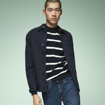Model wearing black and white striped jumper with navy shirt and dark blue jeans. See the styles