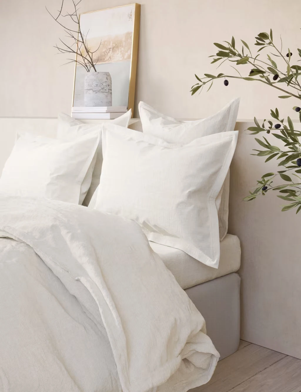 Bed made up with white washed cotton bedding set