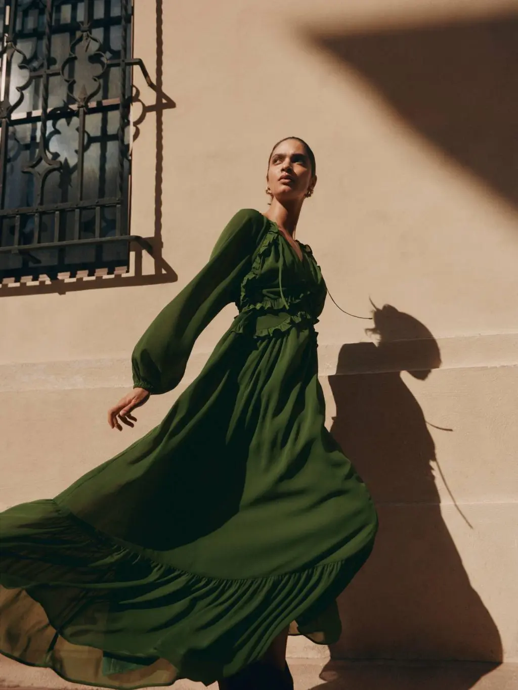 A model walking down the street wearing a green float