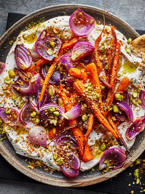 Bowl of roasted carrots with onions and labneh
