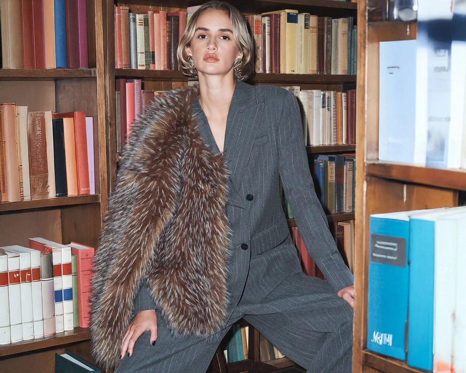 woman wearing grey striped suit and faux fur jacket