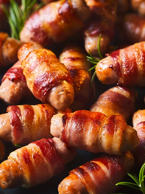 Close up of pigs in blankets and sprigs of rosemary