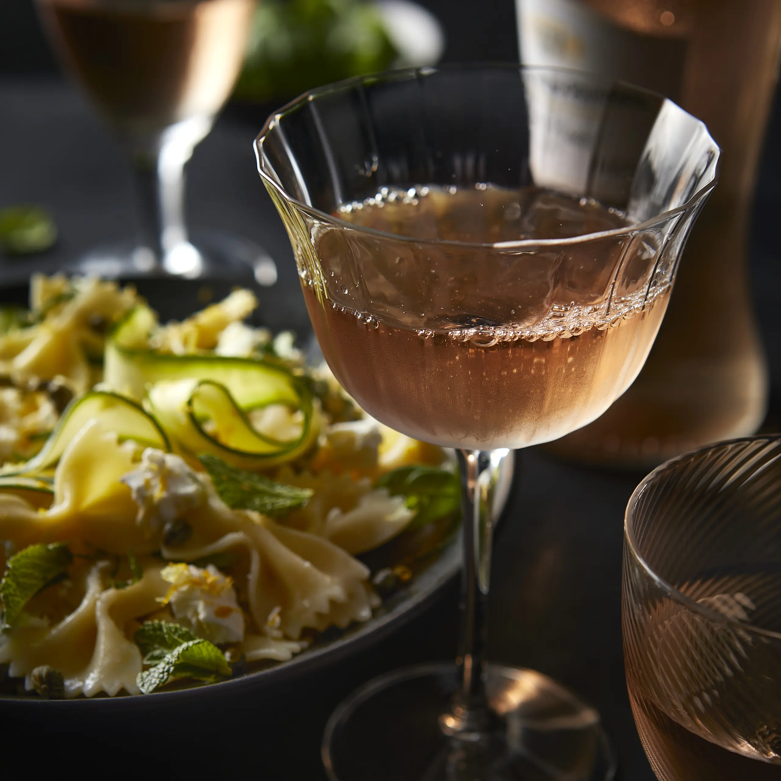 Glass of rosé wine and bowl of pasta