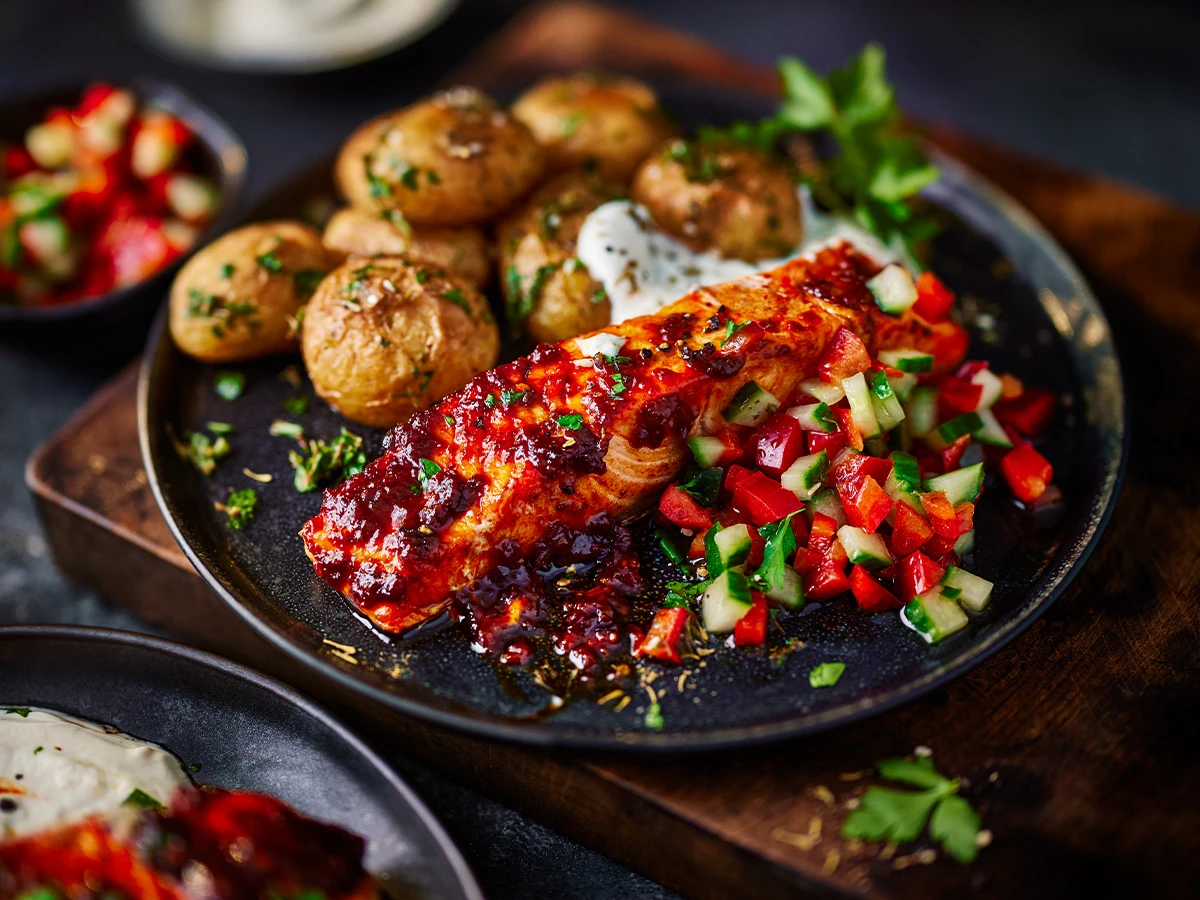 Salmon on black plate with potatoes