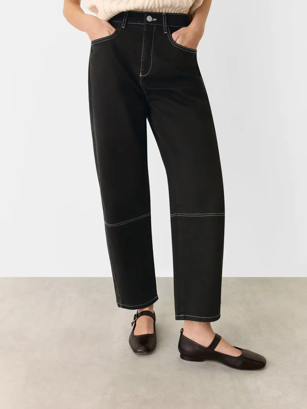 Woman wearing black jeans and black ballet flats