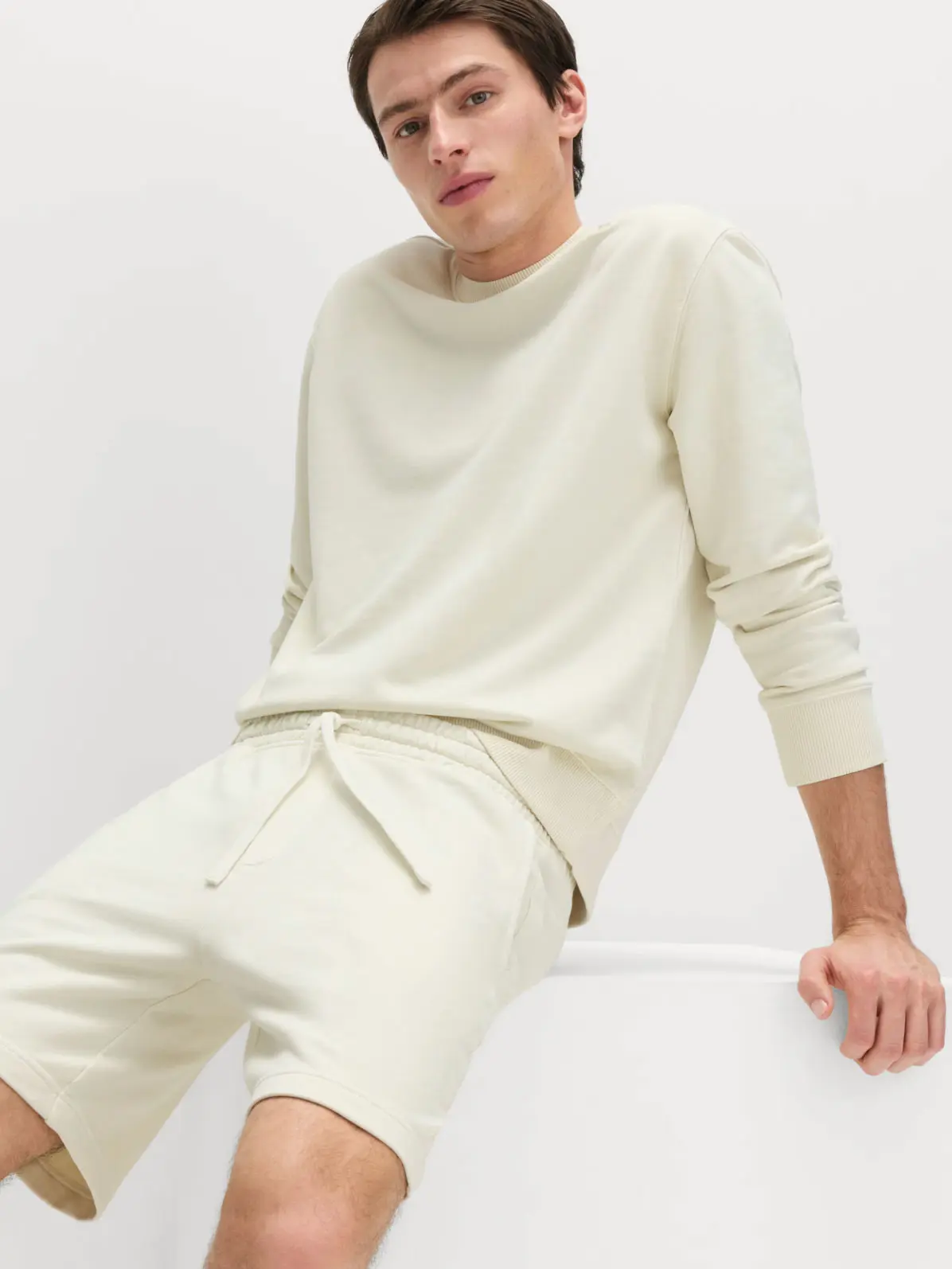 Man wearing sweatshirt and shorts set in cream