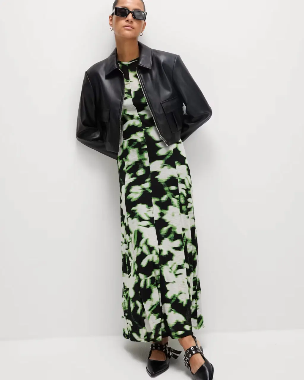 Woman wearing floral dress with faux leather jacket at M&S