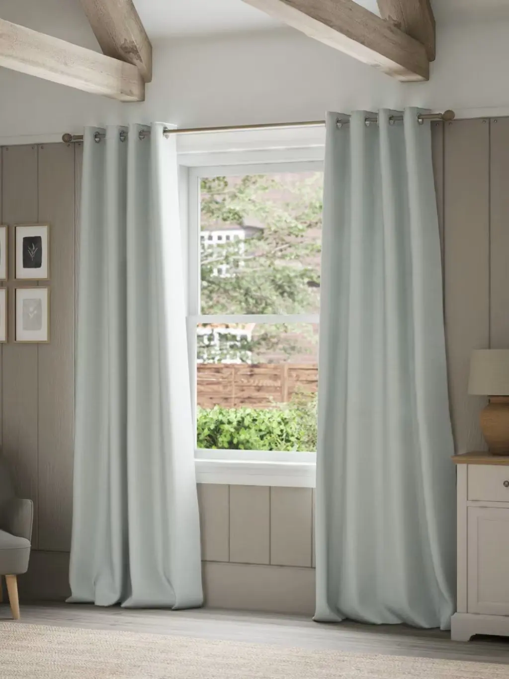 Light blue brushed eyelet curtains hung in a bedroom