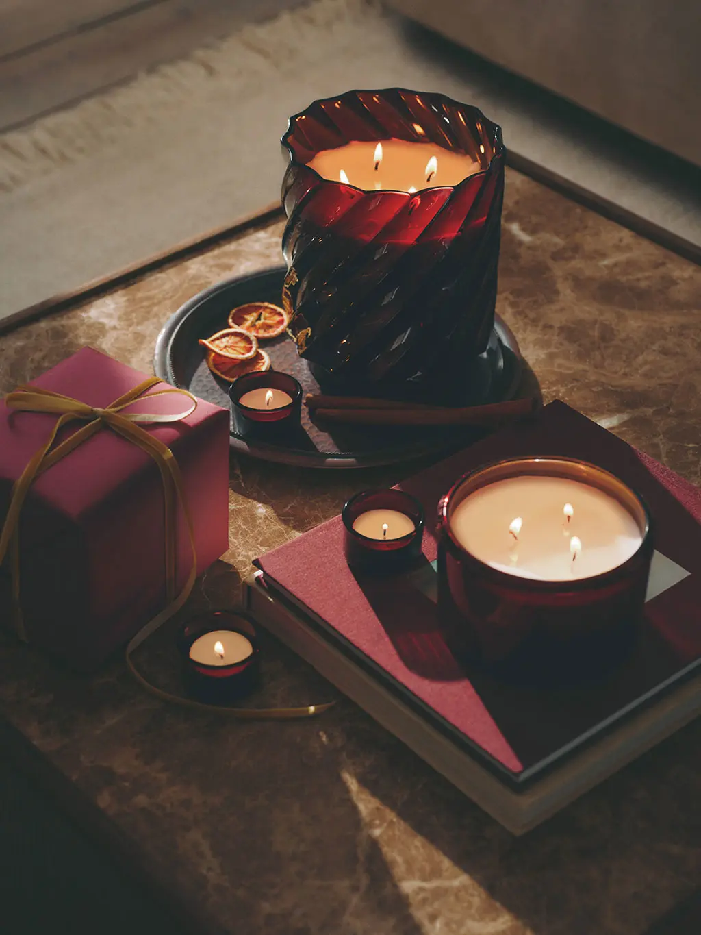 Home setting with two large scented candles on a marble coffee table.