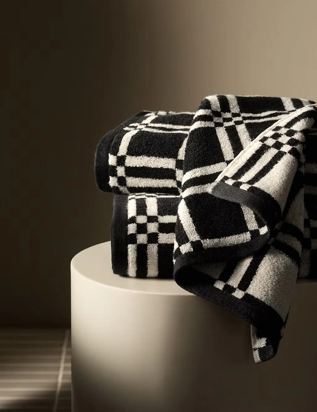Black and white geometric towels on a round side table.