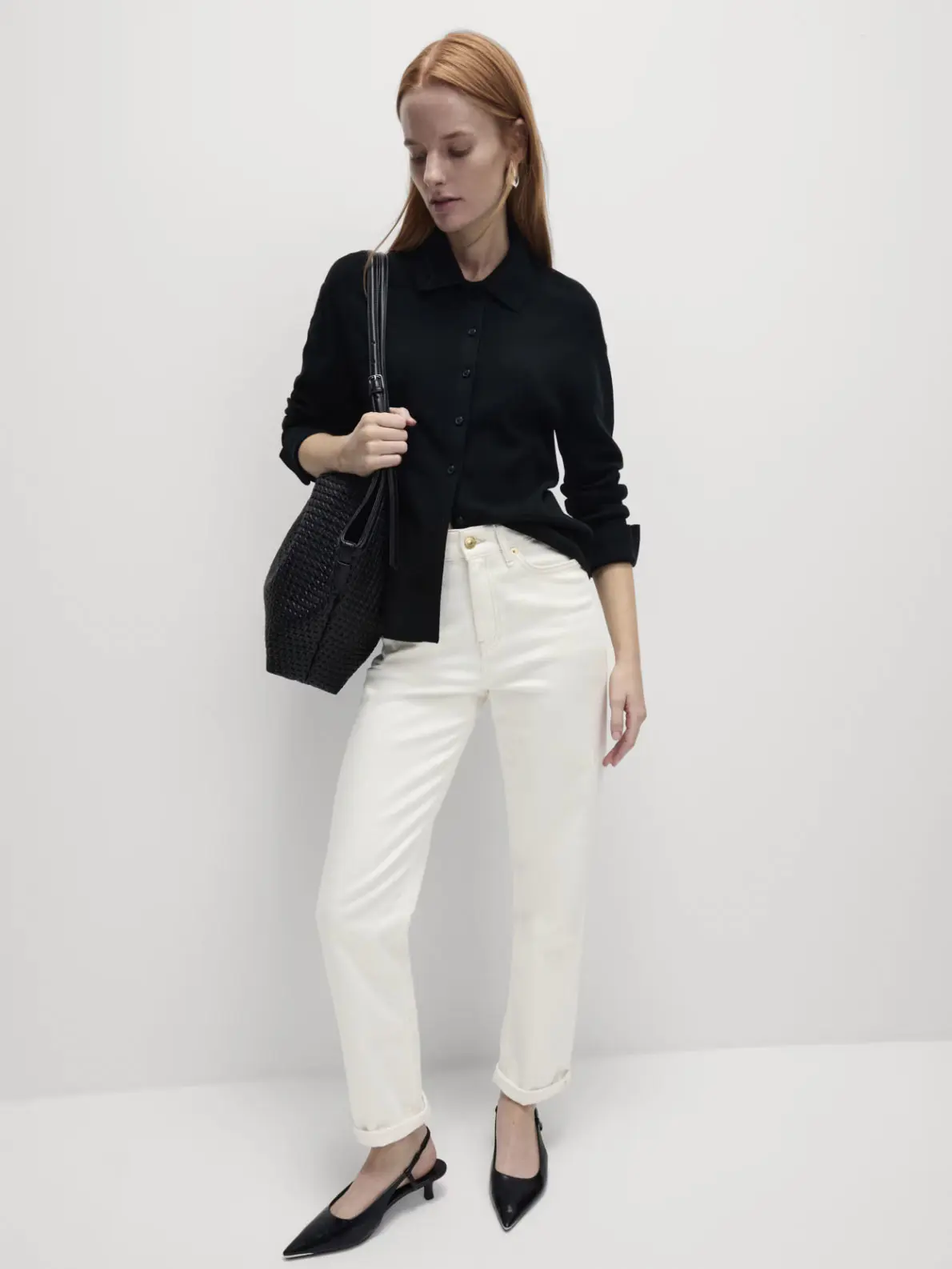 Woman wearing black shirt, white jeans and black kitten heels