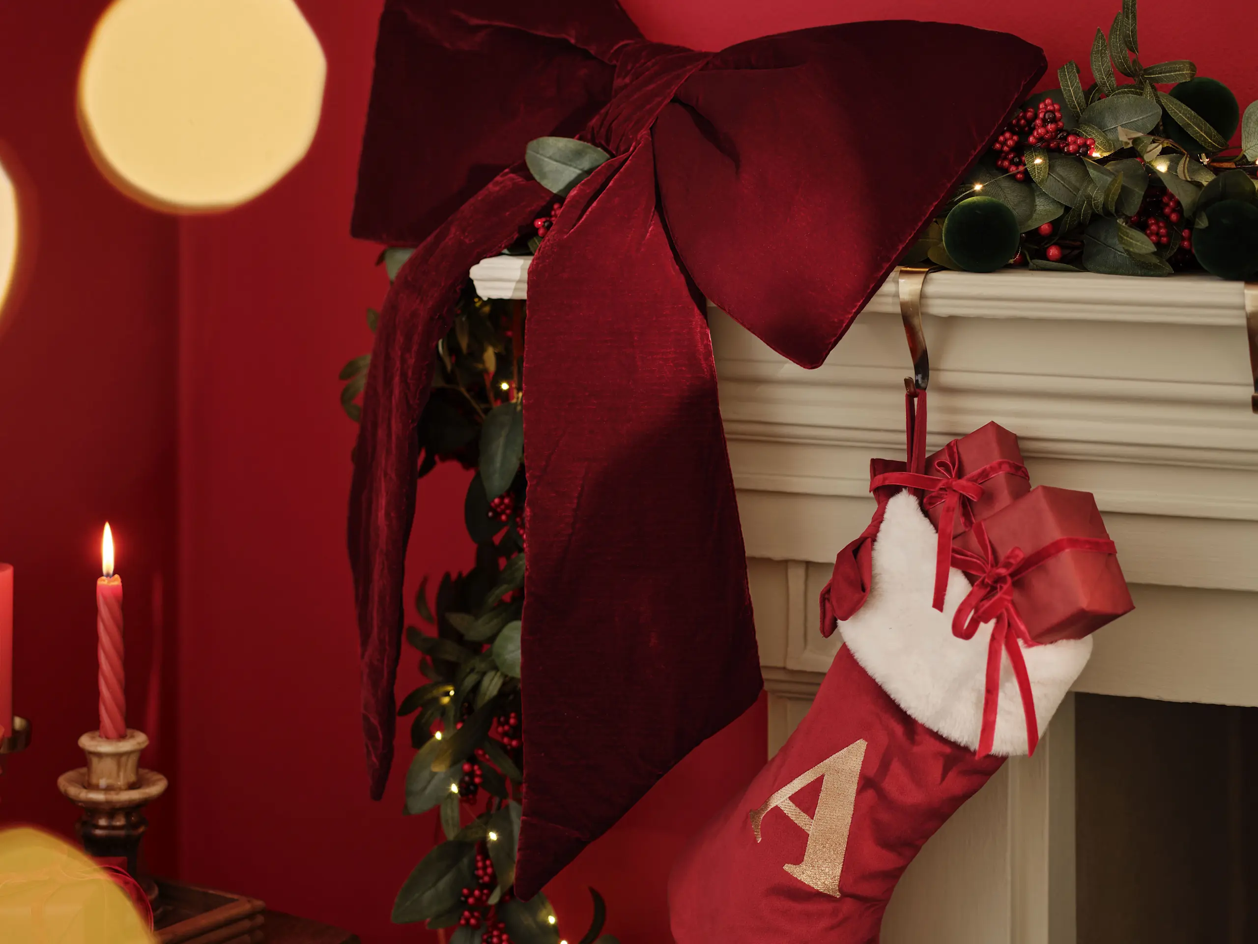Image of red stocking hanging from mantelpiece and a big red bow