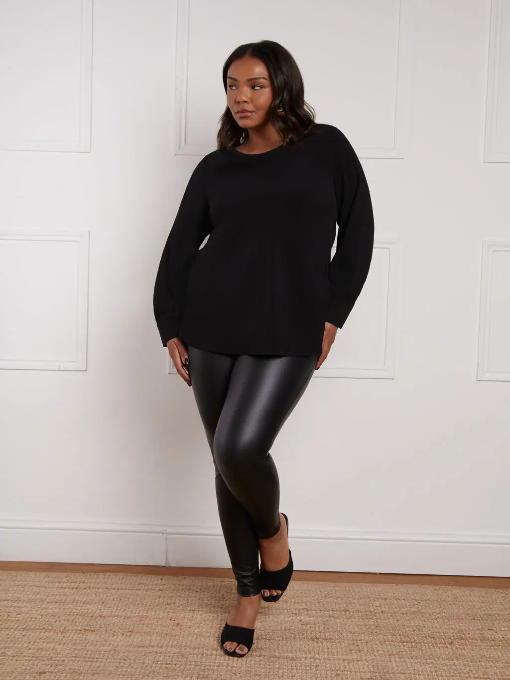 Woman wearing leather leggings and an oversized black jumper