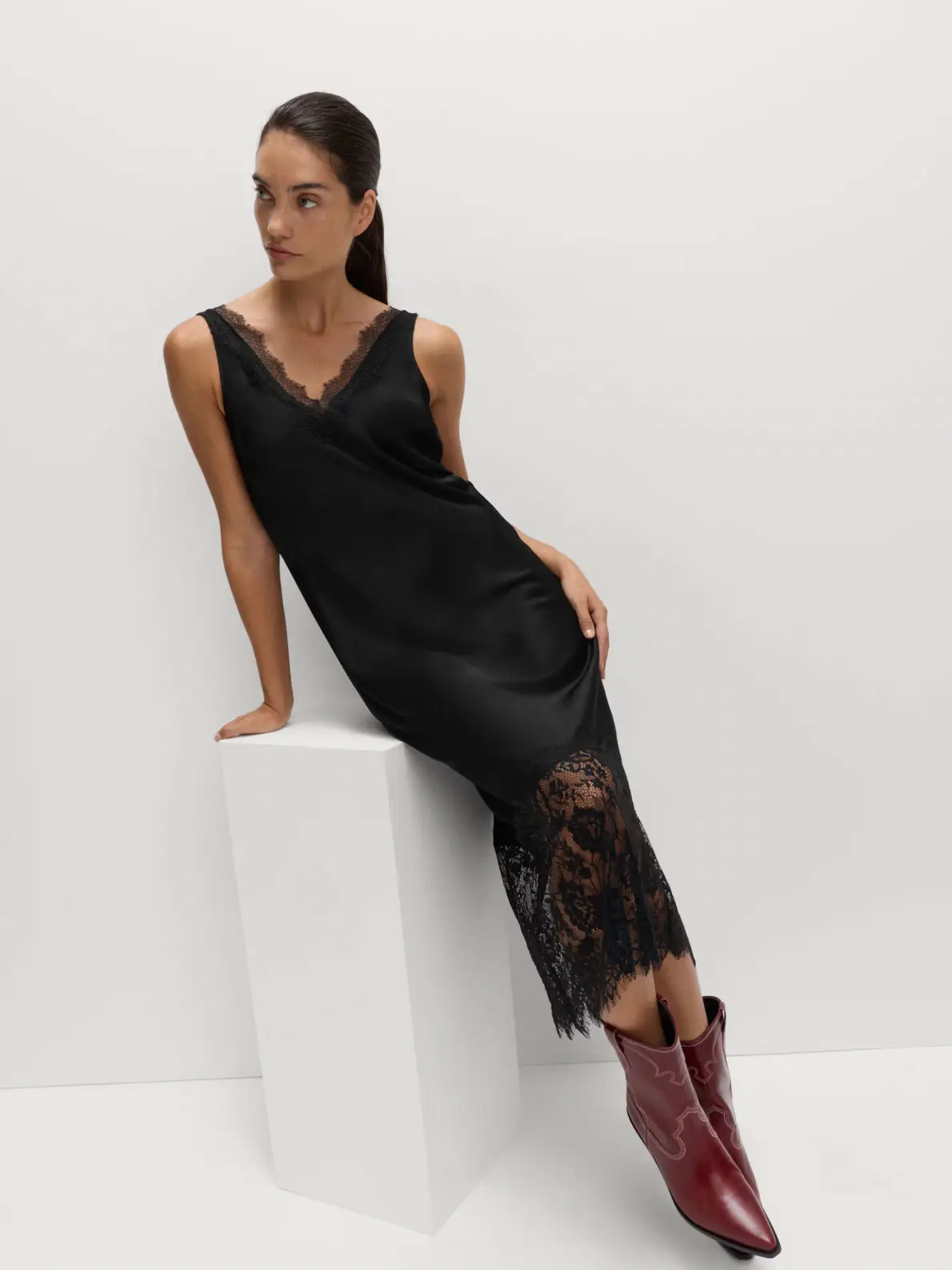 Woman wearing black silky slip dress and cherry red cowboy boots