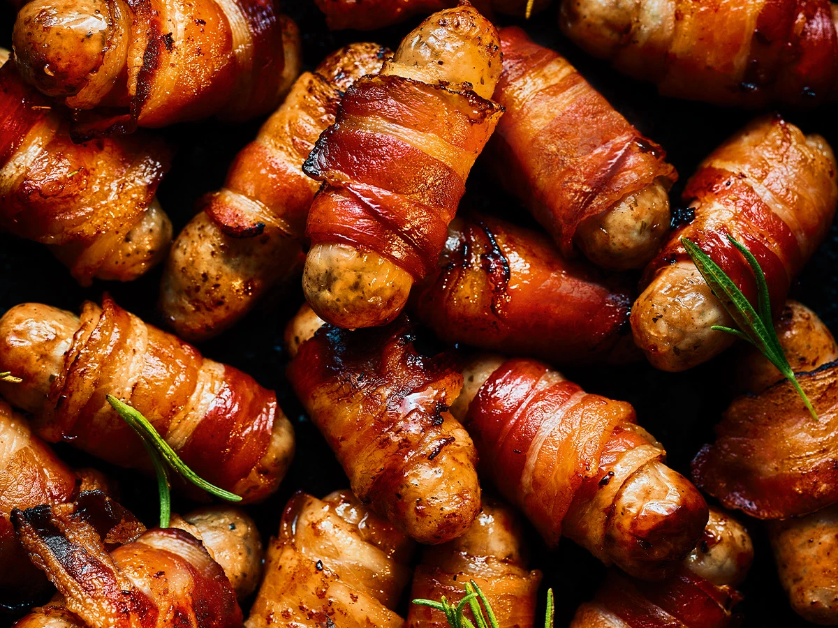Close-up of pigs in blankets and sprigs of rosemary