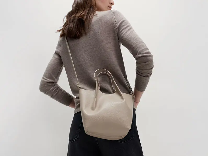 Woman wearing neutral faux-leather cross-body bag