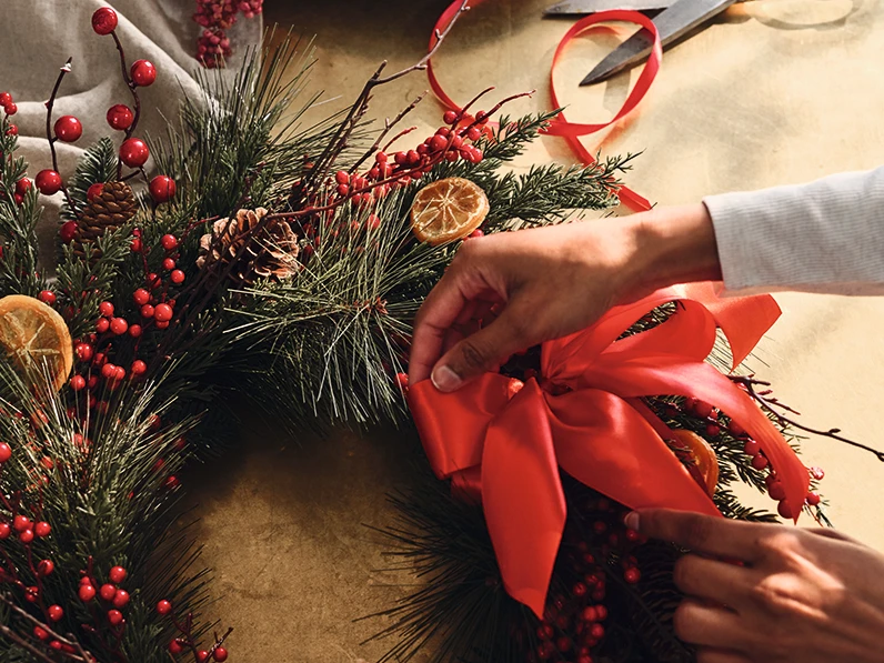 Woman decorating a Christmas wreath