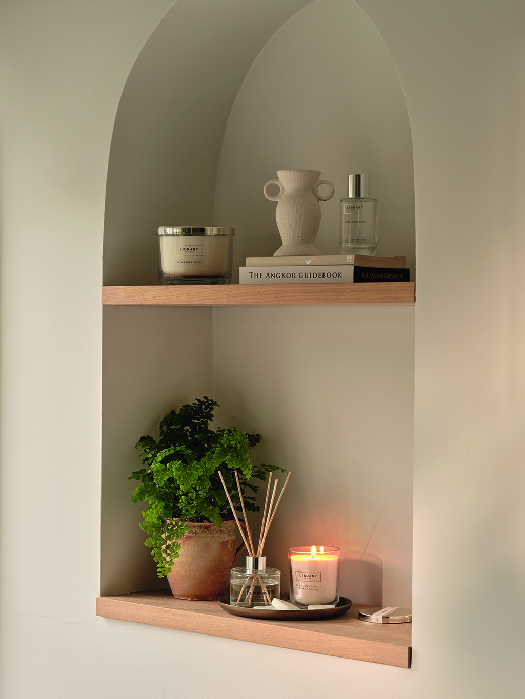 Shelves with scented candles, plants and room diffusers. Shop room fragrance