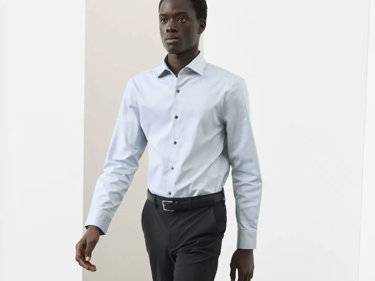 Man wearing a smart blue shirt and trousers 